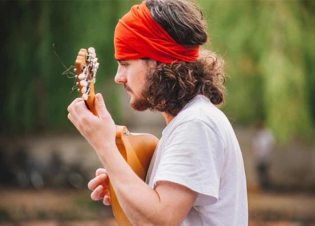 Man in red bandana playing guitar.